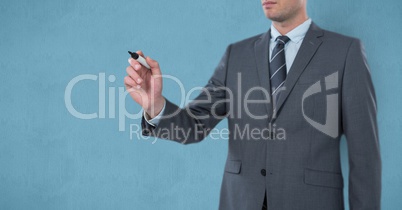 Midsection of businessman writing on imaginary screen over blue background