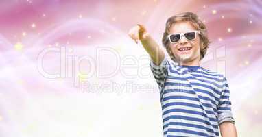 Happy boy wearing sunglasses while pointing over bokeh