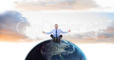 Businessman meditating on globe against sky