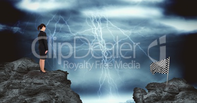 Businesswoman and checked flag over rocks against thunderstorm