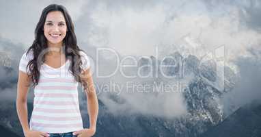 Smiling woman standing against mountains surrounded by fog