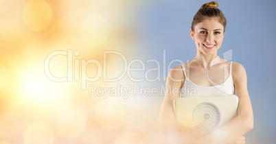 Portrait of fit young woman holding weight scape against bokeh background