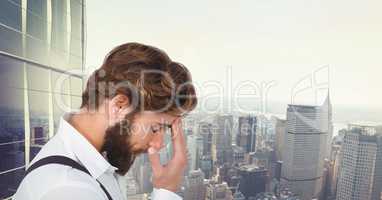 Tensed hipster touching forehead against cityscape