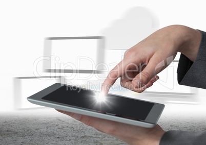 Hands touching tablet with flare against blurry screens