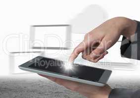 Hands touching tablet with flare against blurry screens