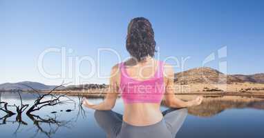 Double exposure of woman meditating at lakeshore