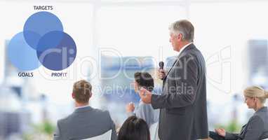 Businessman holding microphone by colleagues