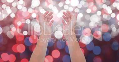 Cropped image of hands over glowing bokeh