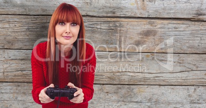 Redhead woman playing video game against wall