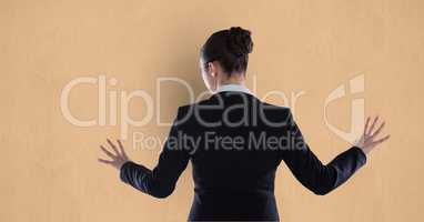 Rear view of businesswoman touching orange background