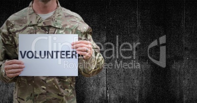 Soldier volunteer mid section against black wood panel