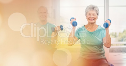 Senior man and woman lifting dumbbells