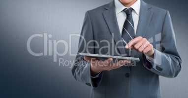Business man mid section with tablet against navy background