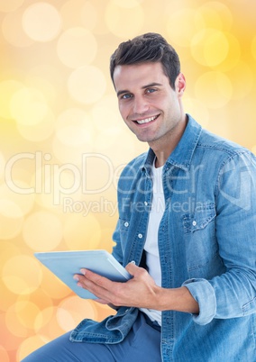 Smiling man holding tablet PC over blur background