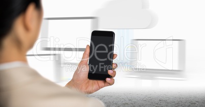 Business woman over shoulder with phone against blurry screens