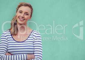 Smiling woman with arms crossed over turquoise background