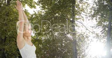Double exposure of woman with hands clasped against trees