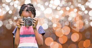 Boy photographing through camera over bokeh