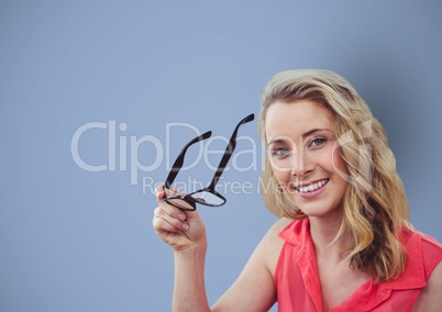 Smiling businesswoman holding eyeglasses over blue background