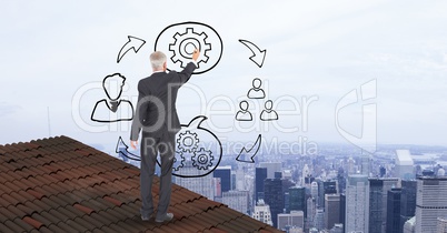 Businessman on roof drawing graphics in midair
