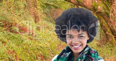 Smiling woman with curly hair in forest