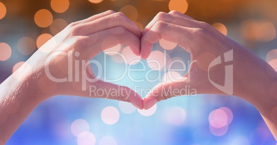 Heart shape made of hands over defocused background