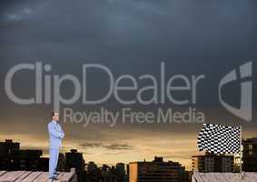 businessman with his hands folded looking to the checker flag in a wood bridge in front of the city