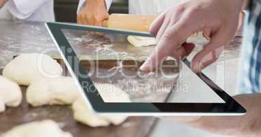 Hand taking picture of dough with tablet PC in bakery