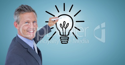 Business man drawing lightbulb doodle with flare against blue background