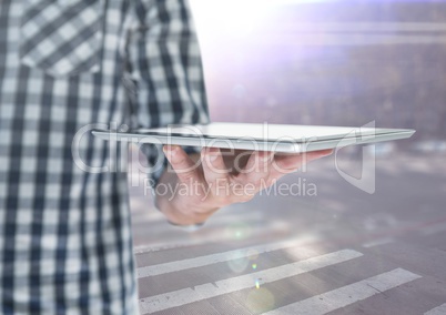 Man mid section with tablet against blurry street with flares