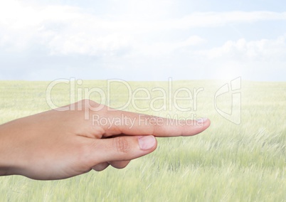 Hand touching  air with  field and sky