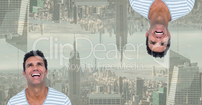 Digital composite image of upside down happy man with city