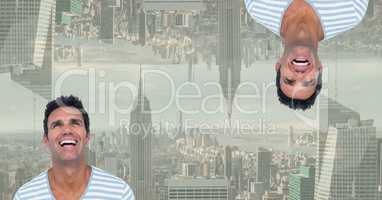 Digital composite image of upside down happy man with city