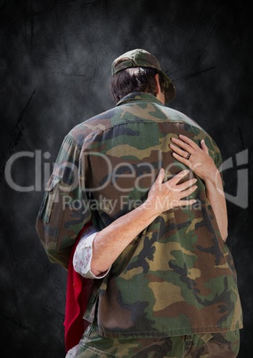 Back of soldier being hugged against black grunge background