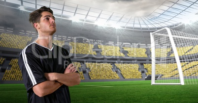 Soccer player with arms crossed at stadium