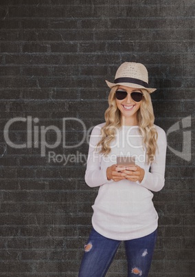 Smiling woman wearing sunhat and sunglasses while using smart phone