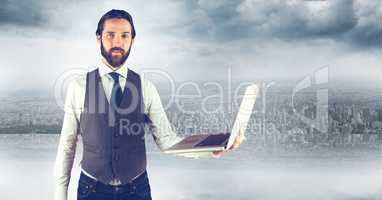 Hipster holding laptop against city