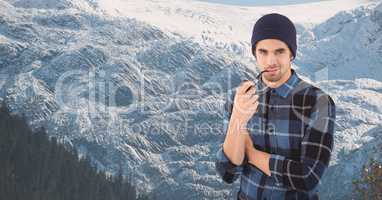 Hipster smoking pipe against snowcapped mountain