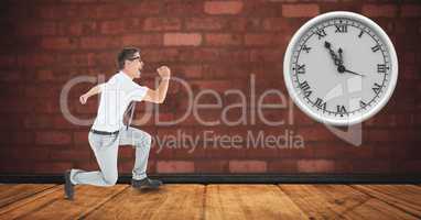 Businessman running with clock mounted on brick wall