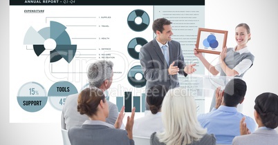 Business people applauding for female executive against graphs
