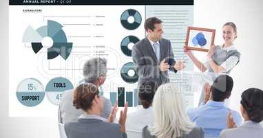 Business people applauding for female executive against graphs