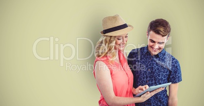 Male and female hipsters using digital tablet against green background