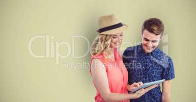 Male and female hipsters using digital tablet against green background