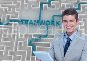 Businessman holding tablet PC while teamwork text connected in maze