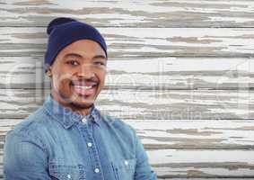 Male hipster wearing knit hat over wooden wall