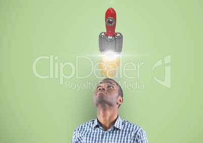 Businessman looking at rocket over head