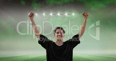 Happy soccer player with arms raised celebrating success