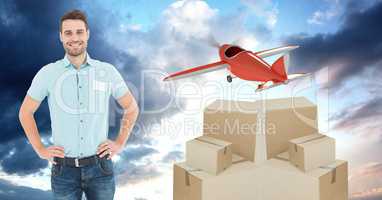 Smiling delivery man with boxes and plane flying in background