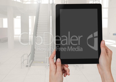 Hands holding a tablet with  airport background