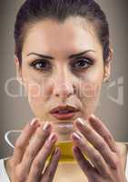 Close up of woman drinking tea against brown background